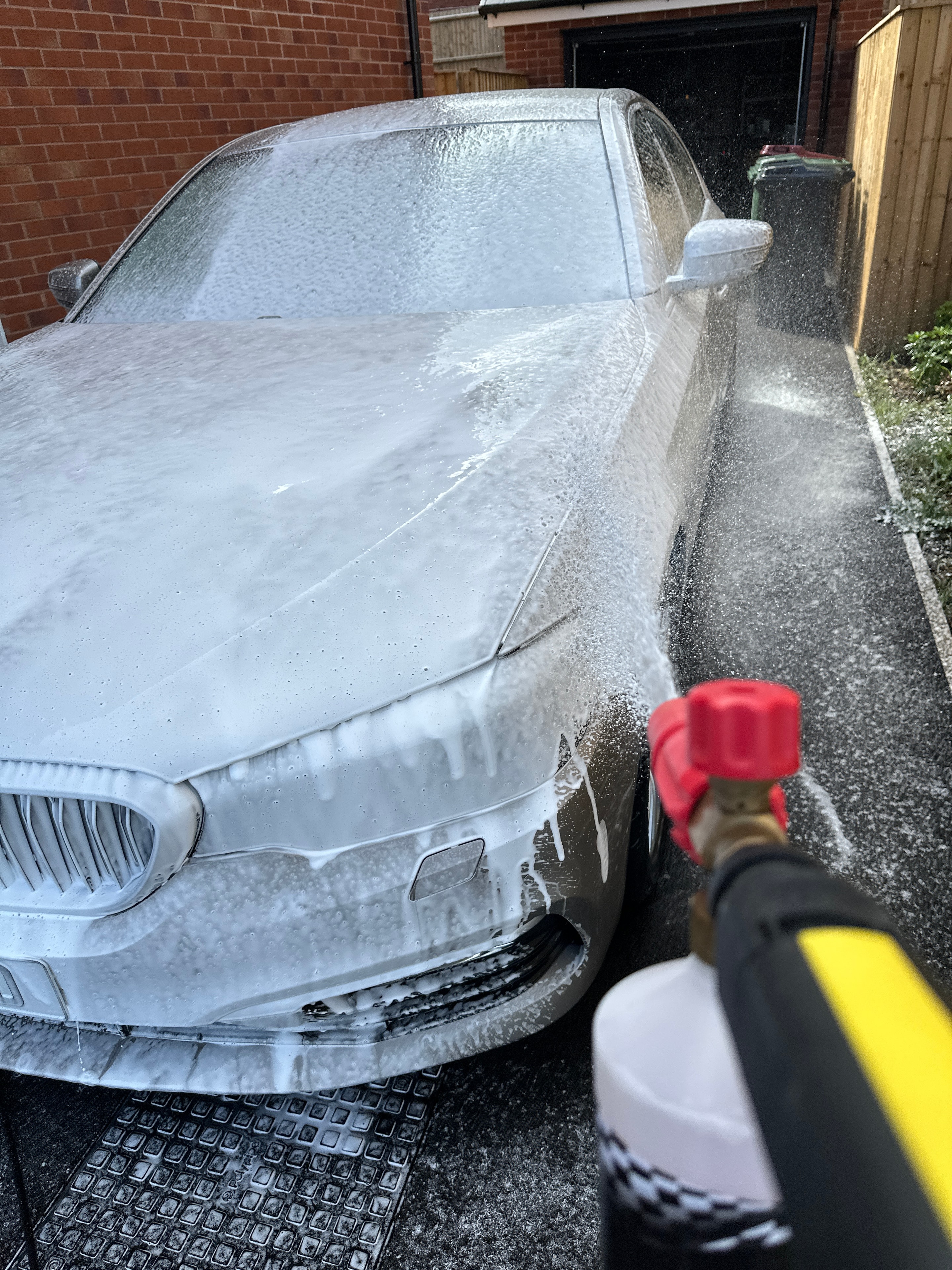 Snow foam applied to car with pressure washer during pre-wash stage